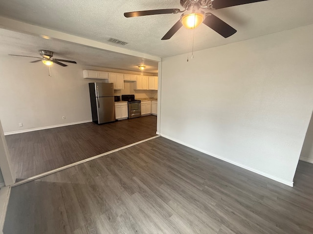 unfurnished living room with ceiling fan, dark hardwood / wood-style floors, and a textured ceiling