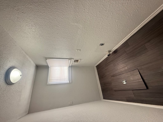 bonus room with a textured ceiling