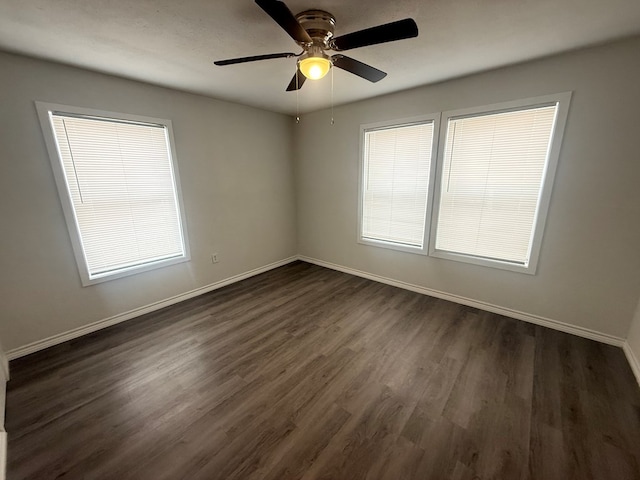 empty room featuring dark wood-type flooring and ceiling fan