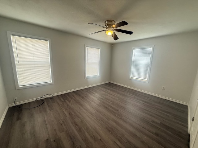 spare room with dark hardwood / wood-style floors and ceiling fan