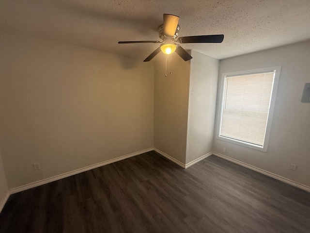 spare room with ceiling fan, dark wood-type flooring, and a textured ceiling