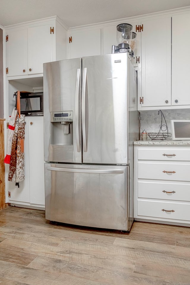 kitchen featuring tasteful backsplash, stainless steel refrigerator with ice dispenser, crown molding, white cabinets, and light wood-type flooring