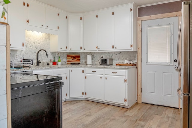 kitchen featuring a textured ceiling, sink, light hardwood / wood-style flooring, white cabinetry, and range with electric stovetop