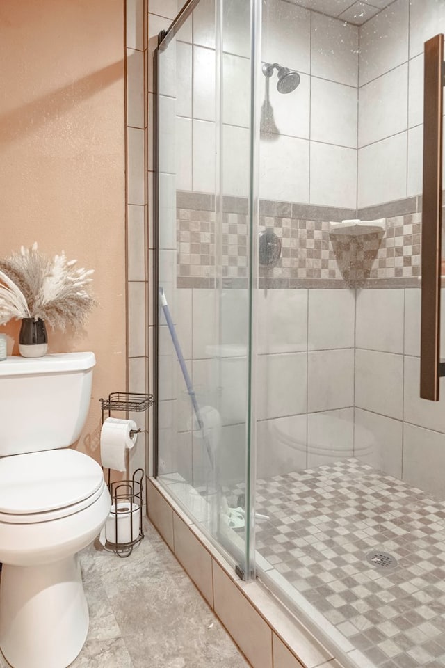 bathroom featuring toilet and an enclosed shower