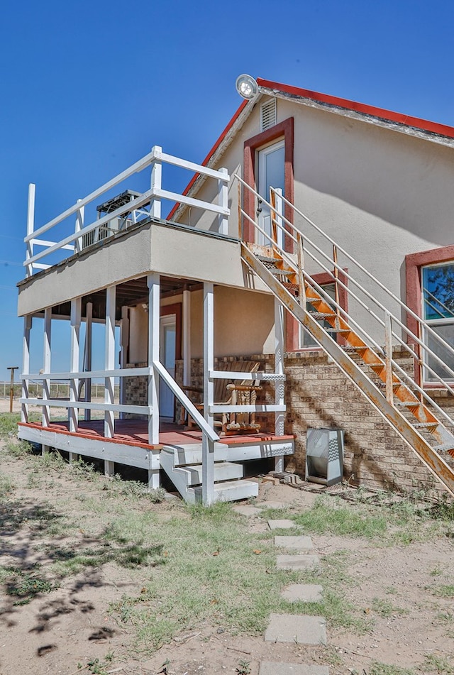 back of house featuring a porch and a balcony