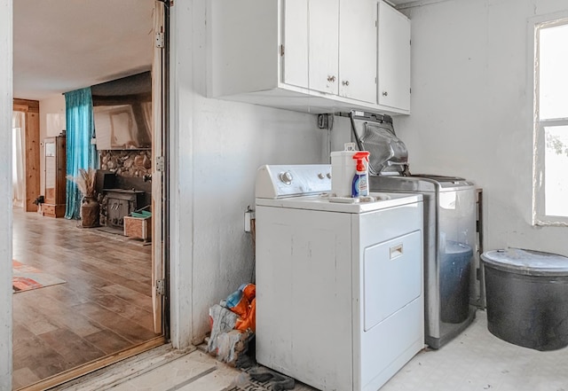 washroom with light hardwood / wood-style floors, cabinets, a healthy amount of sunlight, and independent washer and dryer