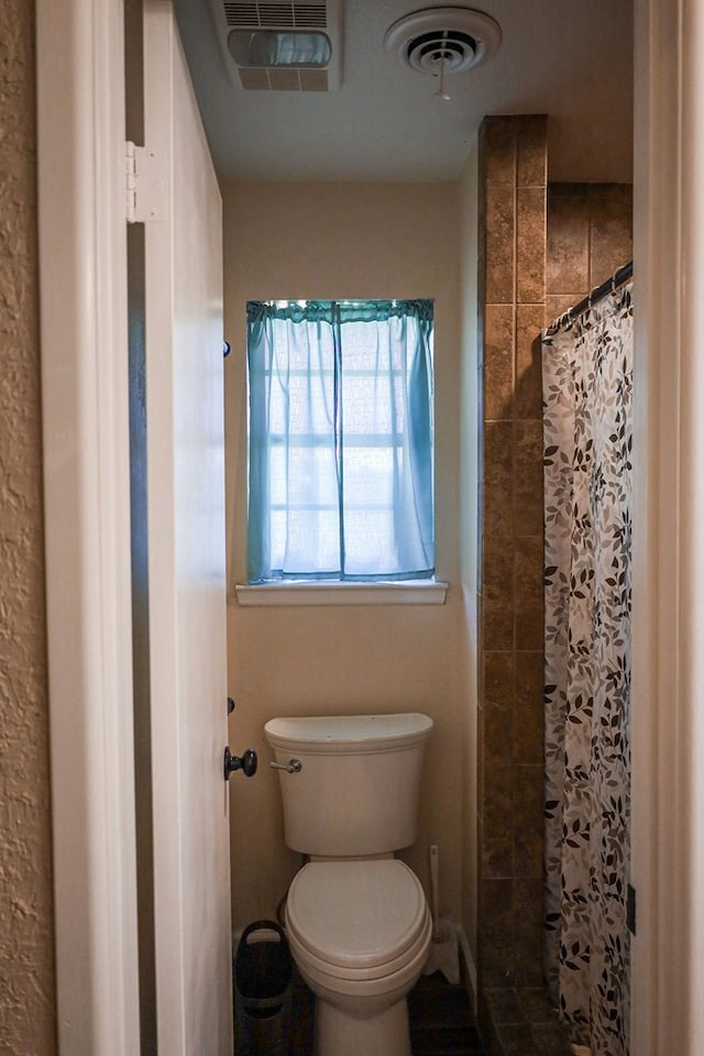 bathroom featuring toilet and a shower with shower curtain