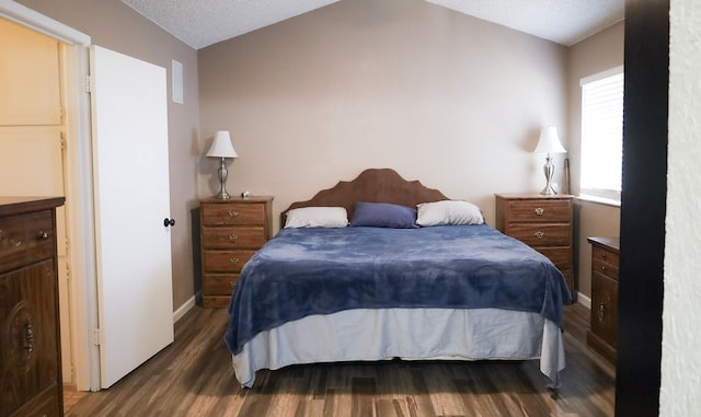 bedroom with dark hardwood / wood-style floors, vaulted ceiling, and a textured ceiling