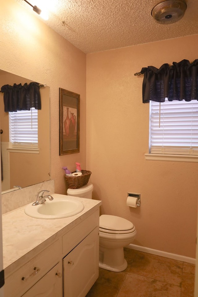 bathroom featuring vanity, tile patterned floors, a textured ceiling, and toilet