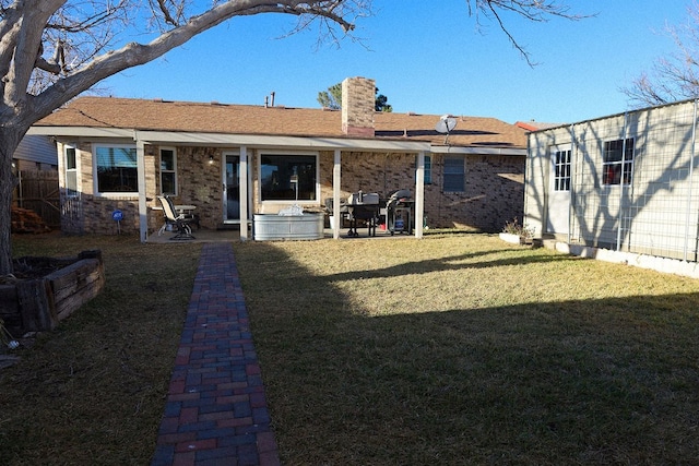 rear view of property with a yard and a patio area