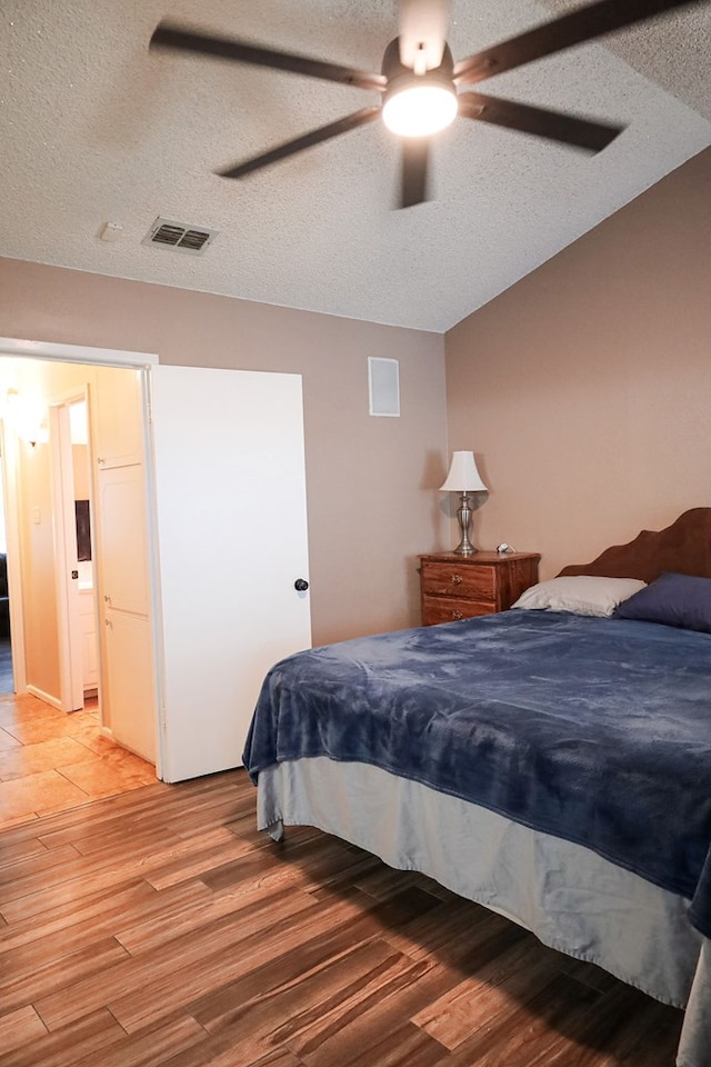 bedroom featuring hardwood / wood-style flooring, ceiling fan, and a textured ceiling