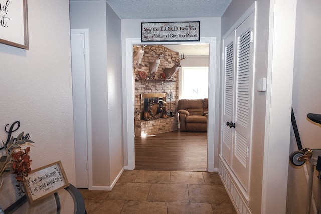 hall with tile patterned floors and a textured ceiling