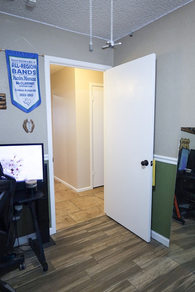 office featuring ceiling fan, hardwood / wood-style floors, and a textured ceiling