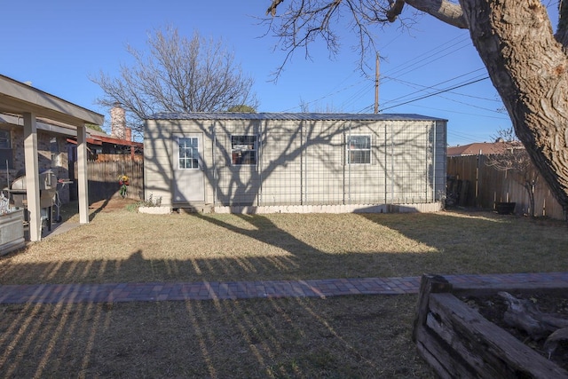 rear view of property with an outbuilding and a lawn