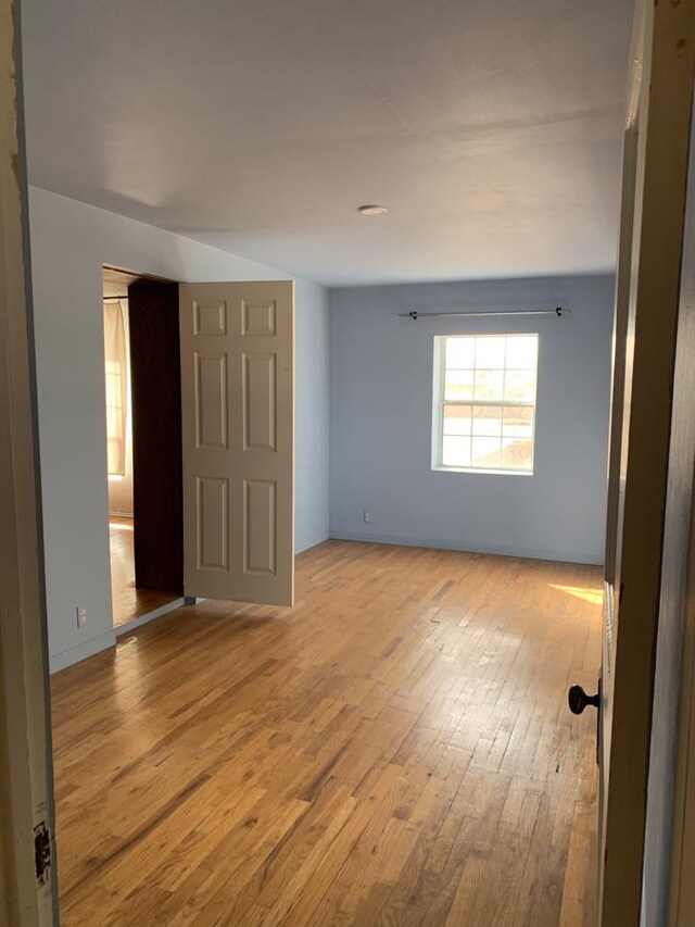 living room featuring crown molding, hardwood / wood-style floors, and a high ceiling