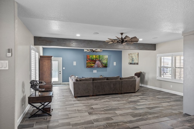 living room featuring a textured ceiling and ceiling fan