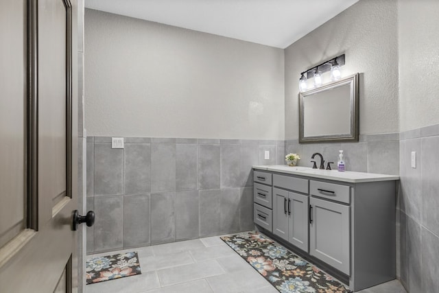 bathroom featuring vanity, tile patterned flooring, and tile walls