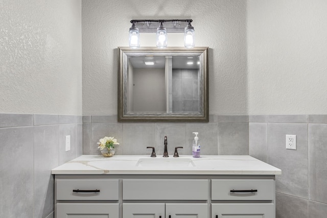 bathroom with vanity and tile walls