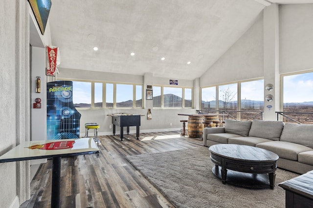 living room with hardwood / wood-style flooring, a mountain view, and a towering ceiling