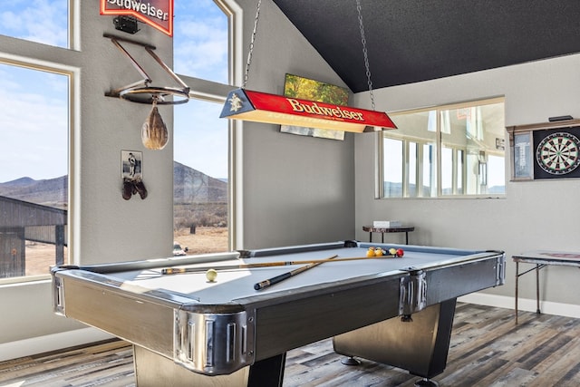 game room with hardwood / wood-style flooring, a healthy amount of sunlight, a mountain view, and vaulted ceiling