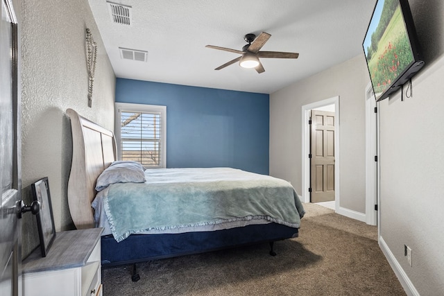 bedroom with ceiling fan, carpet floors, and a textured ceiling