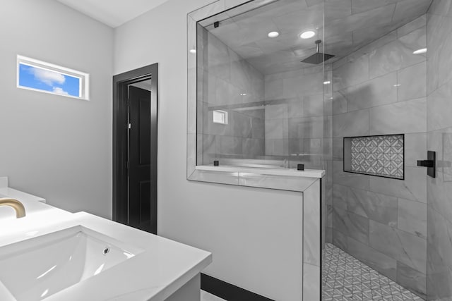 bathroom featuring a tile shower and vanity