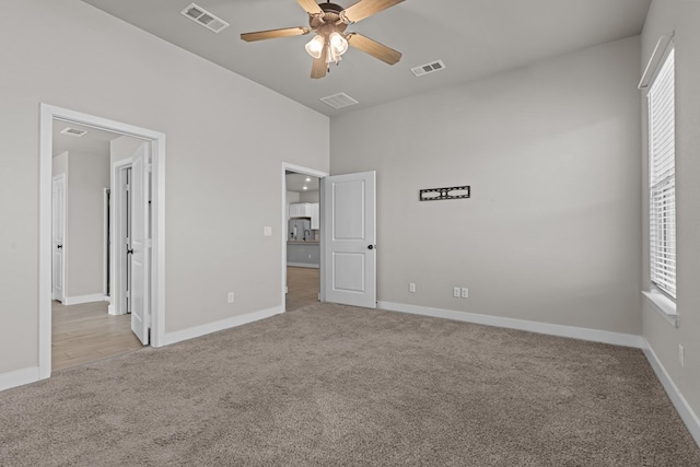 unfurnished bedroom with light carpet, multiple windows, and visible vents