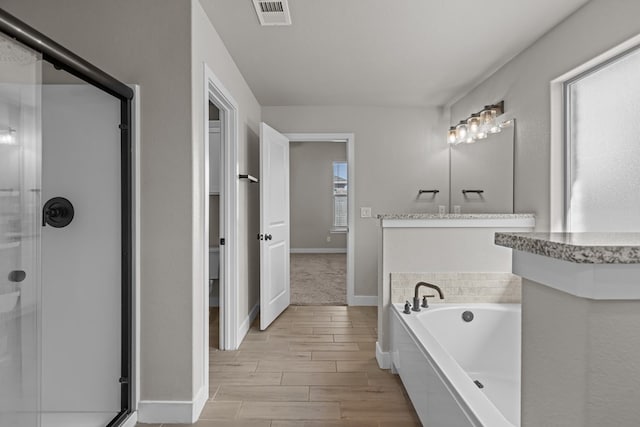 full bathroom with a garden tub, a shower stall, wood tiled floor, and visible vents