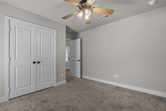 unfurnished bedroom featuring carpet floors, a closet, visible vents, a ceiling fan, and baseboards