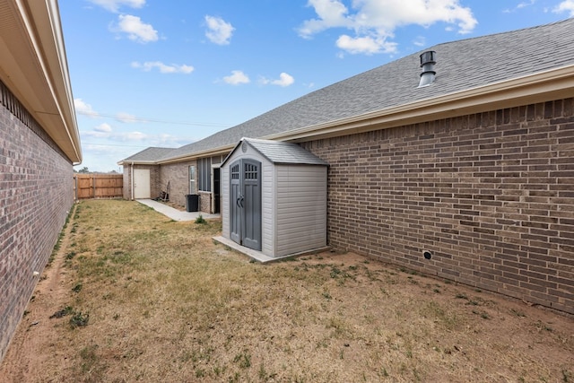 view of yard with a storage shed, a fenced backyard, and an outbuilding