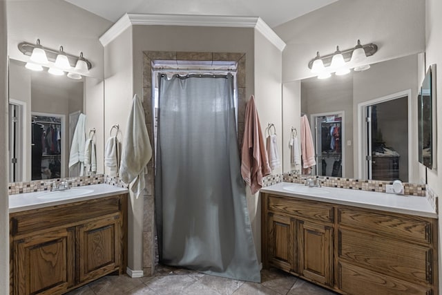 bathroom with a spacious closet, tasteful backsplash, two vanities, and a sink