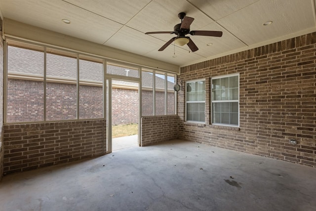 unfurnished sunroom featuring ceiling fan