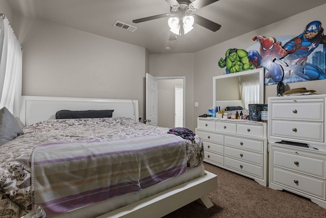 bedroom with visible vents, dark colored carpet, and a ceiling fan