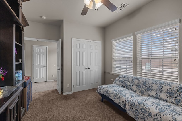 sitting room with carpet floors, tile patterned flooring, visible vents, and a ceiling fan