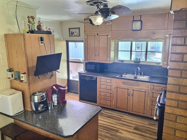 kitchen with sink, ceiling fan, a textured ceiling, black dishwasher, and wood-type flooring