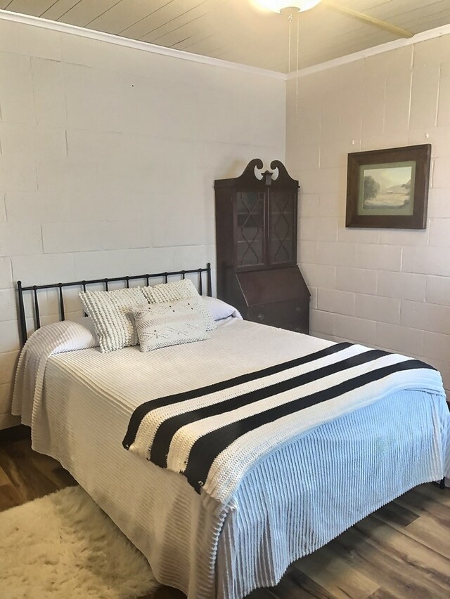 bedroom with crown molding and hardwood / wood-style flooring