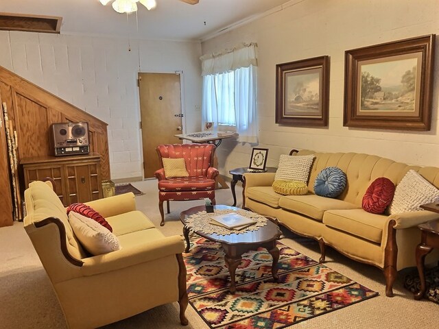 living room featuring carpet, ceiling fan, and ornamental molding