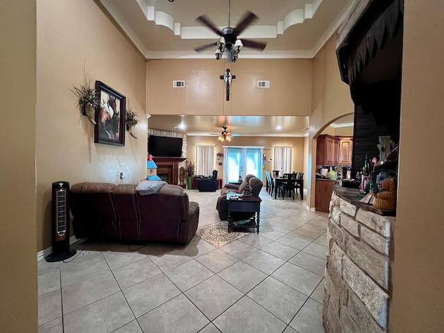 living room with ceiling fan, a raised ceiling, visible vents, and crown molding