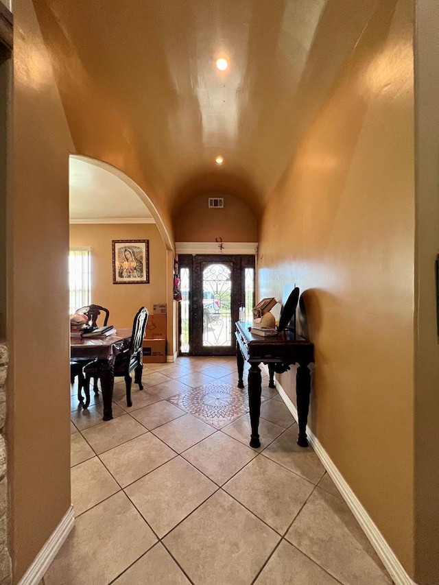 entrance foyer featuring arched walkways, visible vents, lofted ceiling, and baseboards