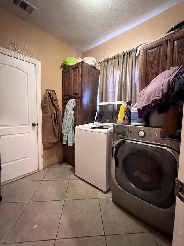 clothes washing area featuring laundry area, visible vents, a textured wall, independent washer and dryer, and a textured ceiling