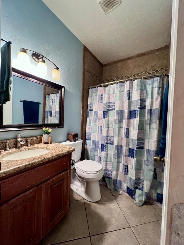 bathroom with visible vents, a textured wall, a textured ceiling, vanity, and tile patterned flooring