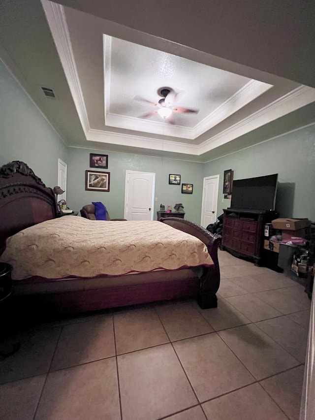 bedroom with a raised ceiling, visible vents, crown molding, and light tile patterned floors