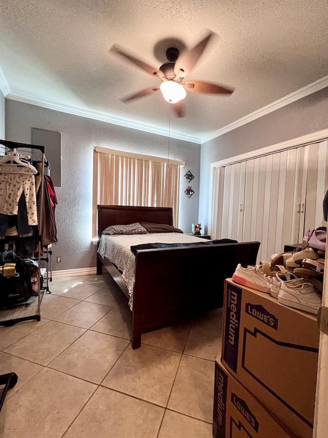 bedroom featuring light tile patterned floors, a textured ceiling, baseboards, and crown molding