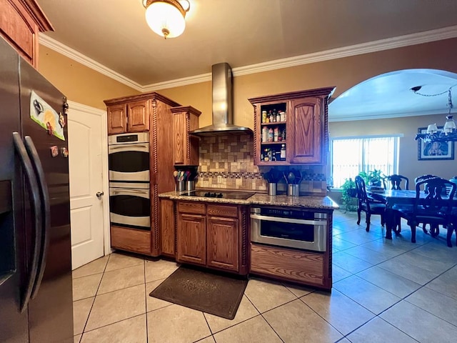 kitchen with appliances with stainless steel finishes, crown molding, wall chimney range hood, open shelves, and light tile patterned flooring