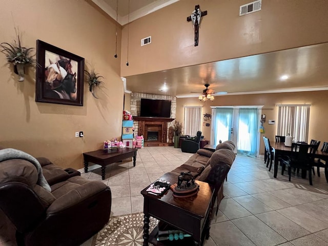 living room with ornamental molding, visible vents, a fireplace, and light tile patterned floors