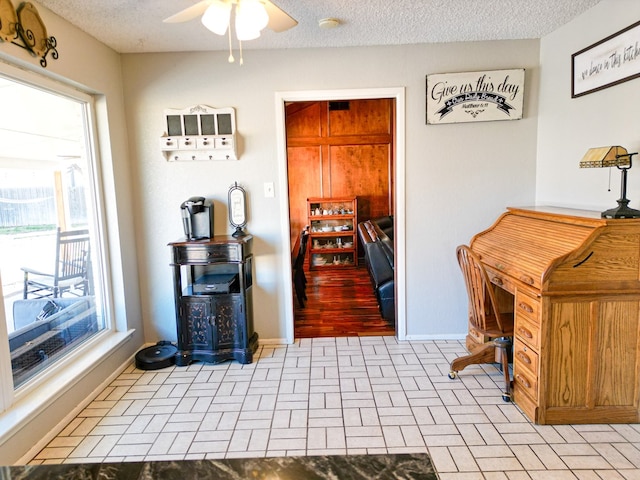 interior space with ceiling fan and a textured ceiling