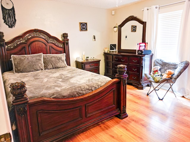 bedroom featuring a textured ceiling and light hardwood / wood-style floors