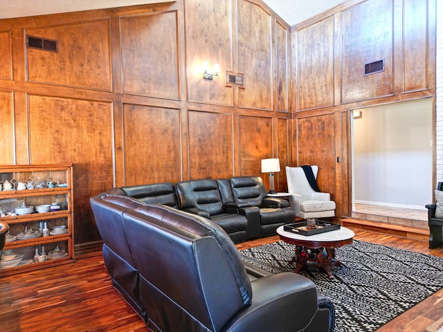 living room with dark hardwood / wood-style floors and wood walls