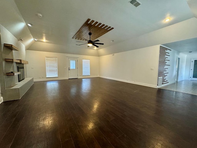 unfurnished living room featuring lofted ceiling, a tile fireplace, dark hardwood / wood-style floors, and ceiling fan