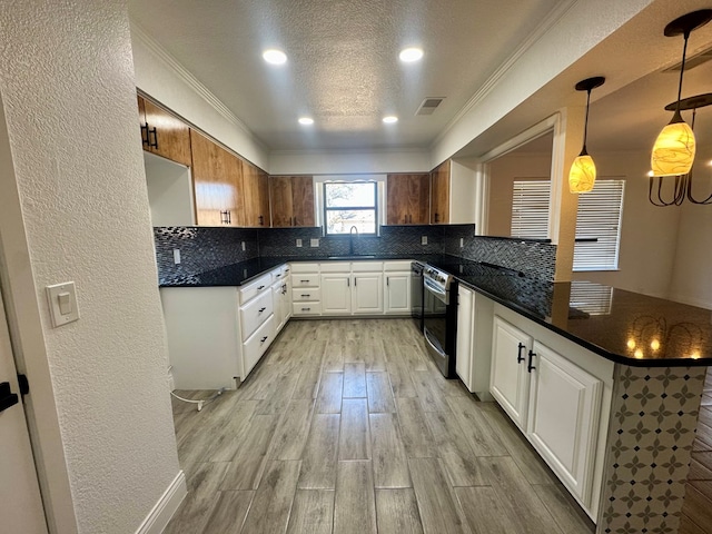 kitchen featuring decorative backsplash, light hardwood / wood-style flooring, hanging light fixtures, and white cabinets